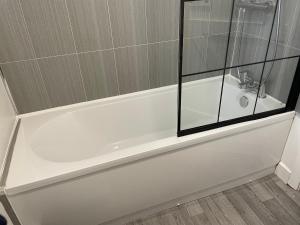 La salle de bains est pourvue d'une baignoire blanche et d'un lavabo. dans l'établissement Sarn Y Mynach - Traditional Welsh Cottage, à Llandudno Junction 10 autres photos