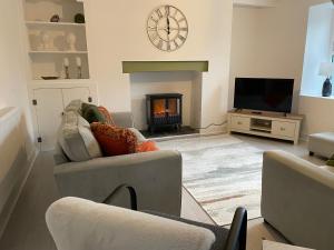 un salon avec une cheminée et une télévision dans l'établissement Sarn Y Mynach - Traditional Welsh Cottage, à Llandudno Junction