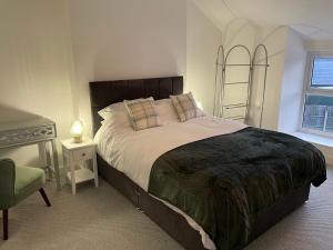 une chambre avec un grand lit et un bureau dans l'établissement Sarn Y Mynach - Traditional Welsh Cottage, à Llandudno Junction