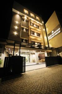 a building at night with a building in the background at Maruti Group of Hotels - The Shivam in Nāthdwāra