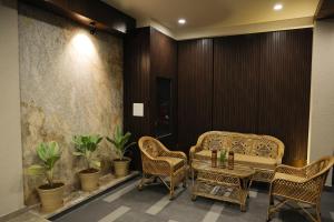 a room with two chairs and a table and some plants at Maruti Group of Hotels - The Shivam in Nāthdwāra