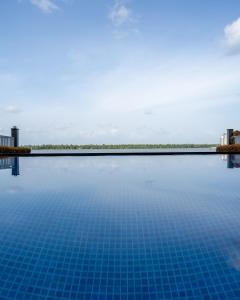 ein Pool mit blauem Wasser und Gebäude im Hintergrund in der Unterkunft Kent Baywatch Suites in Kochi