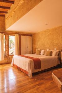 1 dormitorio con cama y ventana grande en Cabañas y Spa Las Pircas en Tandil