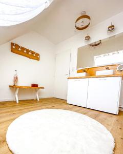 a kitchen with white cabinets and a white rug at Le cocon de Normandy in Criquebeuf-sur-Seine