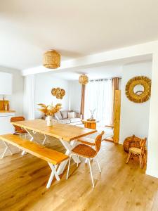 sala de estar con mesa de madera y sillas en Le cocon de Normandy, en Criquebeuf-sur-Seine