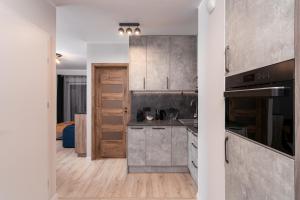 a kitchen with gray cabinets and a counter top at ApartWro 8th - City Square, Railway Station (balcony, garage) in Wrocław