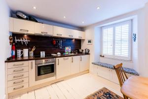 a kitchen with white cabinets and a table and a window at Pass the Keys The Lofthouse St Monans in Anstruther
