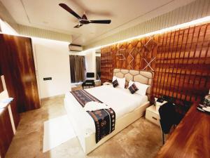 a bedroom with a large bed and a ceiling fan at THE GREENSTAR INN PREMIUM in Bhubaneshwar
