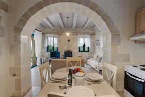 Kókkinon KhoríonにあるVilla Polihymnia St George Retreat BY APOKORONAS-VILLASのキッチン、アーチ道のあるダイニングルーム