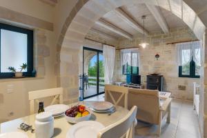 Kókkinon KhoríonにあるVilla Polihymnia St George Retreat BY APOKORONAS-VILLASのテーブルと椅子のあるキッチンとダイニングルーム