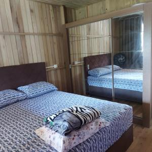 um quarto com duas camas e um espelho em Casa Jardim em Balneário Gaivotas