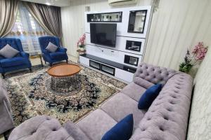 - un salon avec un canapé et une télévision dans l'établissement Hani Raisha Homestay, Seksyen 7 Shah Alam, à Shah Alam