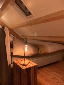 ein Schlafzimmer mit einem Bett und einem Tisch mit einer Lampe in der Unterkunft Vakantiehuis Hollestelle in Ovezande