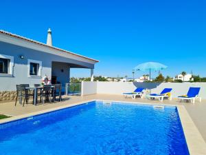 una villa con piscina, tavolo e sedie di Casa Limão - Private Pool - Beach & Center (650m) a Carvoeiro
