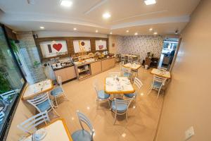 a restaurant with tables and chairs and a kitchen at Pousada Villa Atlântica in Balneário Camboriú