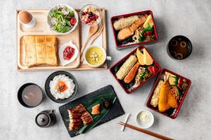 una mesa con platos de comida y tazones de comida en ホテル 尼乃美楽 尼崎 en Amagasaki