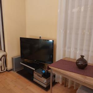 a living room with a flat screen tv and a table at Casa Negoiu in Târgu-Mureş