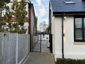 una entrada a una casa blanca con una valla en The Studio Heald Green en Handforth