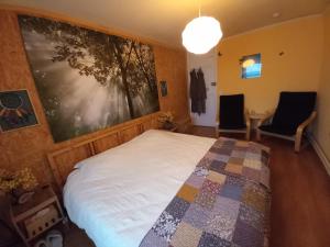 1 dormitorio con 1 cama y 2 sillas en B&B De Zonnepoort vzw, en Hasselt