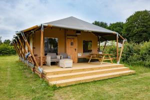 a house with a deck and a tent at Glamping de Bosweide in Alphen