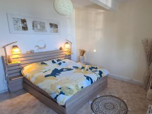 a bedroom with a bed with a blue and yellow comforter at Le Cocon de Madana in Saint-Joseph