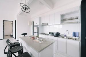 JelutongにあるNEW Infinity Pool Seaview 3Bedrooms 2Carparks 262の白いキッチン(カウンター、椅子付)