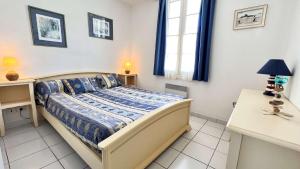 una camera da letto con un letto, una scrivania e una finestra di Petite location dans résidence avec piscine et terrains de tennis a La Couarde-sur-Mer