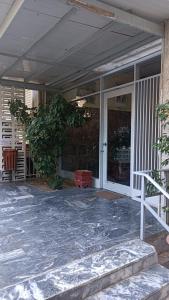 un porche delantero de una casa con un árbol. en SeaSide House 37 Θουκιδιδου,Alimos, en Atenas
