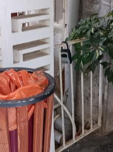 a trash can next to a white chair and a plant at SeaSide House 37 Θουκιδιδου,Alimos in Athens