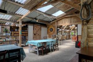 a barn with a table and chairs in a room at Glamping de Bosweide in Alphen