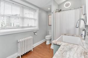 a bathroom with a sink and a toilet and a window at Underground Railroad 3 Bedroom Farmhouse in Kennett Square +22 photos