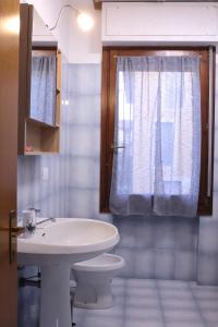 uma casa de banho com um lavatório, um WC e uma janela. em A Casa di Francesca em Lucca
