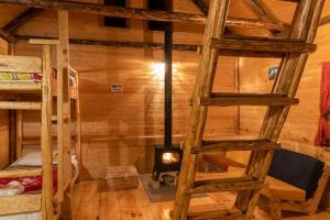 una habitación con estufa de leña en una cabaña en Mestia Eco Huts en Mestia