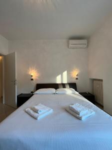 - un lit blanc avec 2 serviettes dans l'établissement Dolce Dimora, à Stresa