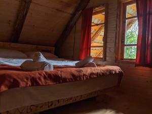 una persona acostada en una cama en una habitación con ventanas en Mestia Eco Huts en Mestia
