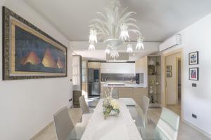 a dining room with a table with chairs and a painting at Charming Apartment La Pollona in Torino