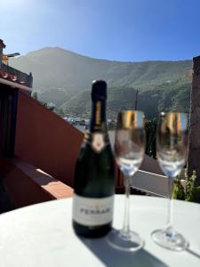 una botella de vino sentada en una mesa con dos copas en Precioso apartamento con terraza en piso superior en Los Realejos