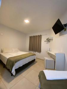 1 dormitorio con 1 cama y lavamanos. en Recanto Bromélias en Camburi