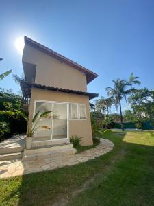 una casa con una ventana en un patio en Recanto Bromélias en Camburi