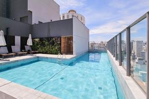 a swimming pool on the roof of a building at Piscina no Rooftop! Studio a 3min do Metrô República in Sao Paulo