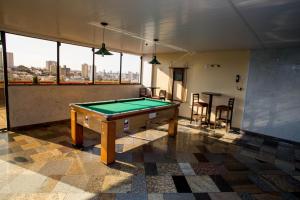 una mesa de billar en una habitación con vistas a la ciudad en Hotel Nacional Inn Campinas Trevo, en Campinas