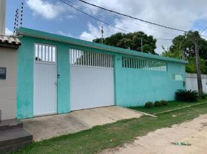un edificio azul y blanco con dos puertas de garaje en Casa em Tamandaré Próximo ao Mar, en Tamandaré 7 fotos más