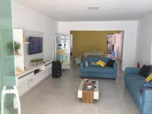 Una sala de estar con un sofá azul y una mesa. en Casa em Tamandaré Próximo ao Mar, en Tamandaré