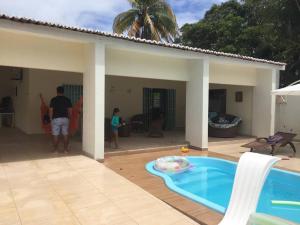 un hombre y un niño parados junto a una piscina en Casa em Tamandaré Próximo ao Mar, en Tamandaré