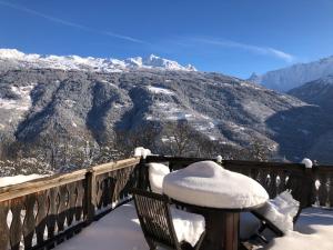 uma varanda coberta de neve com vista para uma montanha em Chambre d’hôtes em Les Chapelles