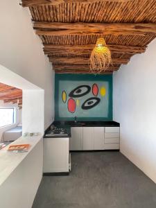 a kitchen with a painting on the wall at Dar Isma : Une maison sur océan in Wassane