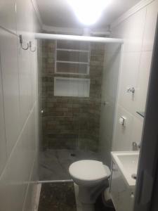 a bathroom with a shower with a toilet and a sink at Apartamento Toninhas in Ubatuba