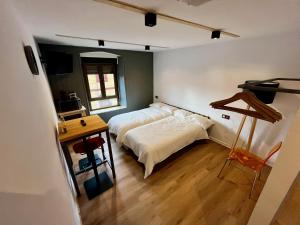 a bedroom with a bed and a table in it at The Orange Teddy Bear Hostal La Peña in Mieres