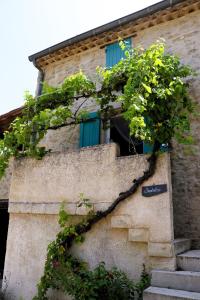 een gebouw met een trap en een raam met groene luiken bij Les Demeures du Clos in Niozelles
