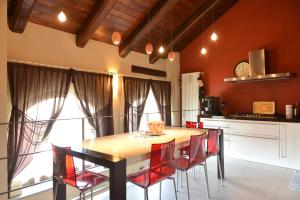 Casa Vacanze Il Brichet في مونْدوفي: مطبخ مع طاولة خشبية وكراسي حمراء